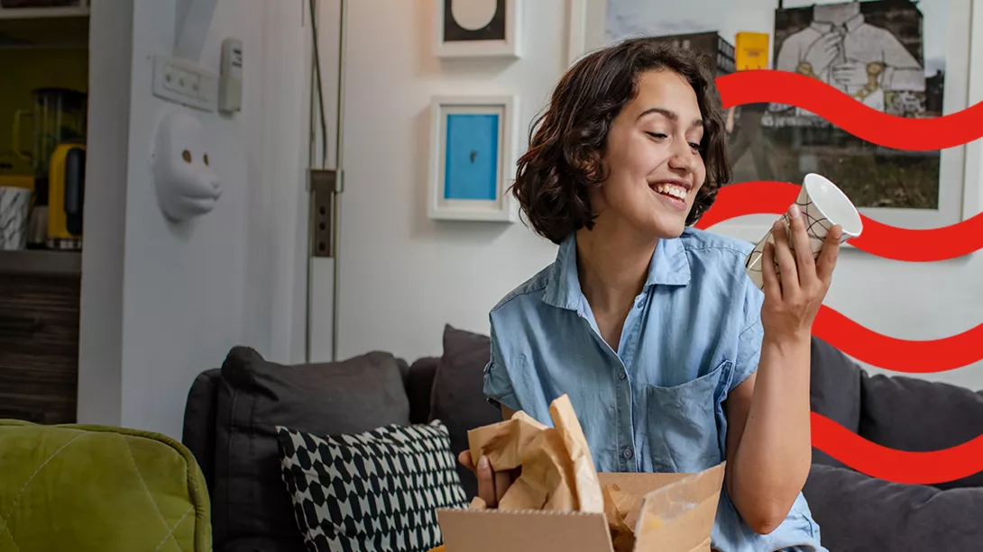 woman smiling opening a box with new purchase