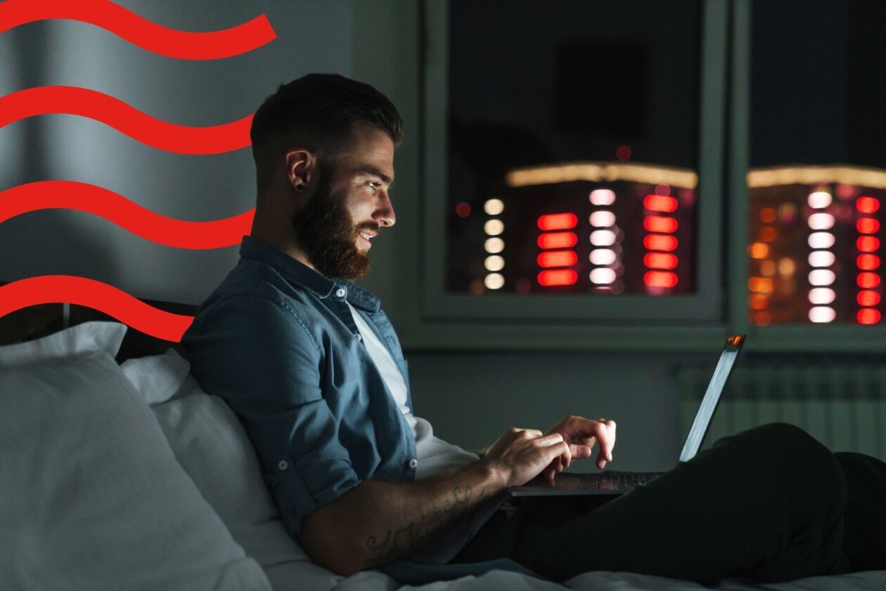 man sitting at laptop on the sofa in a dark room