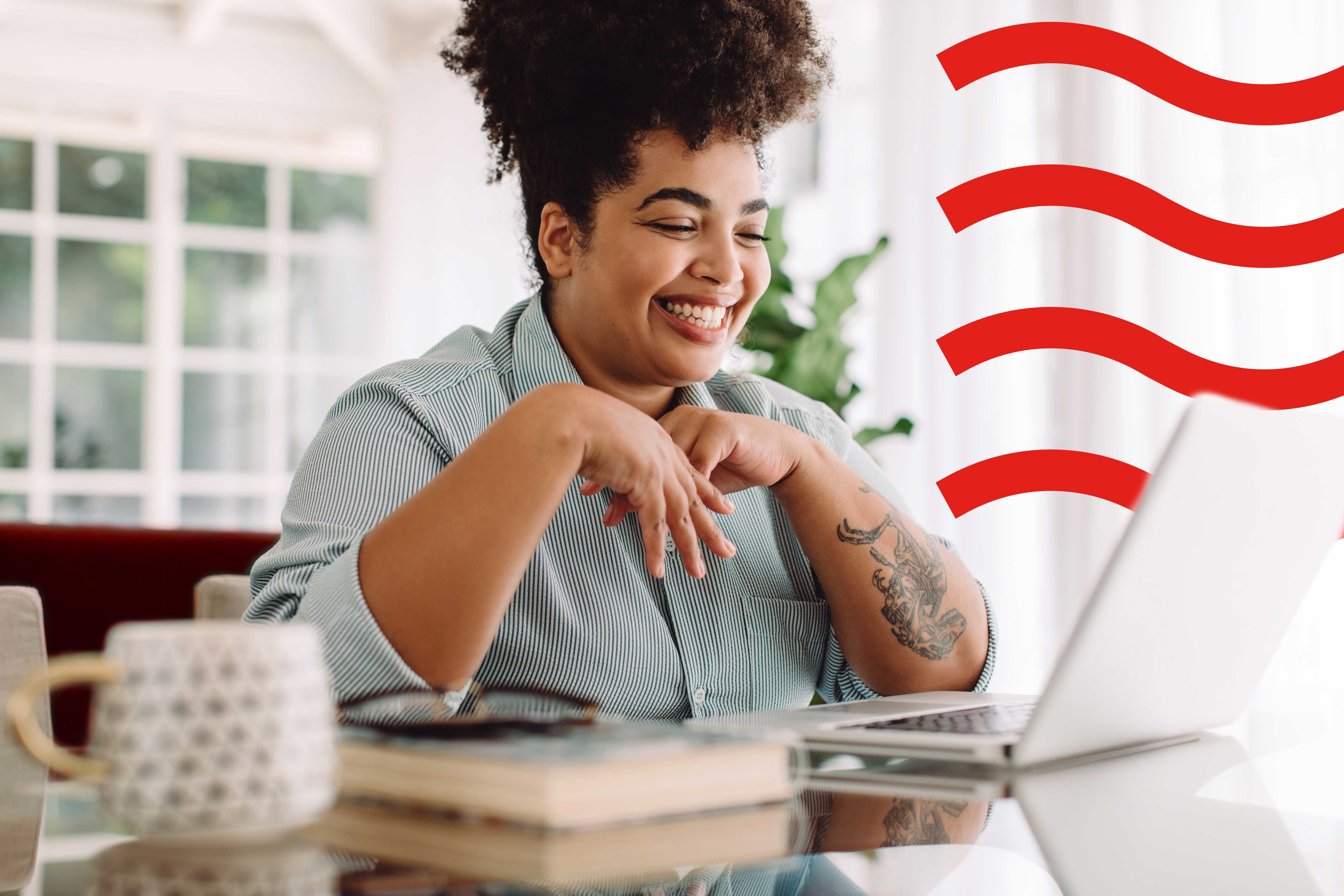 Woman smiling sitting at the table on her laptop