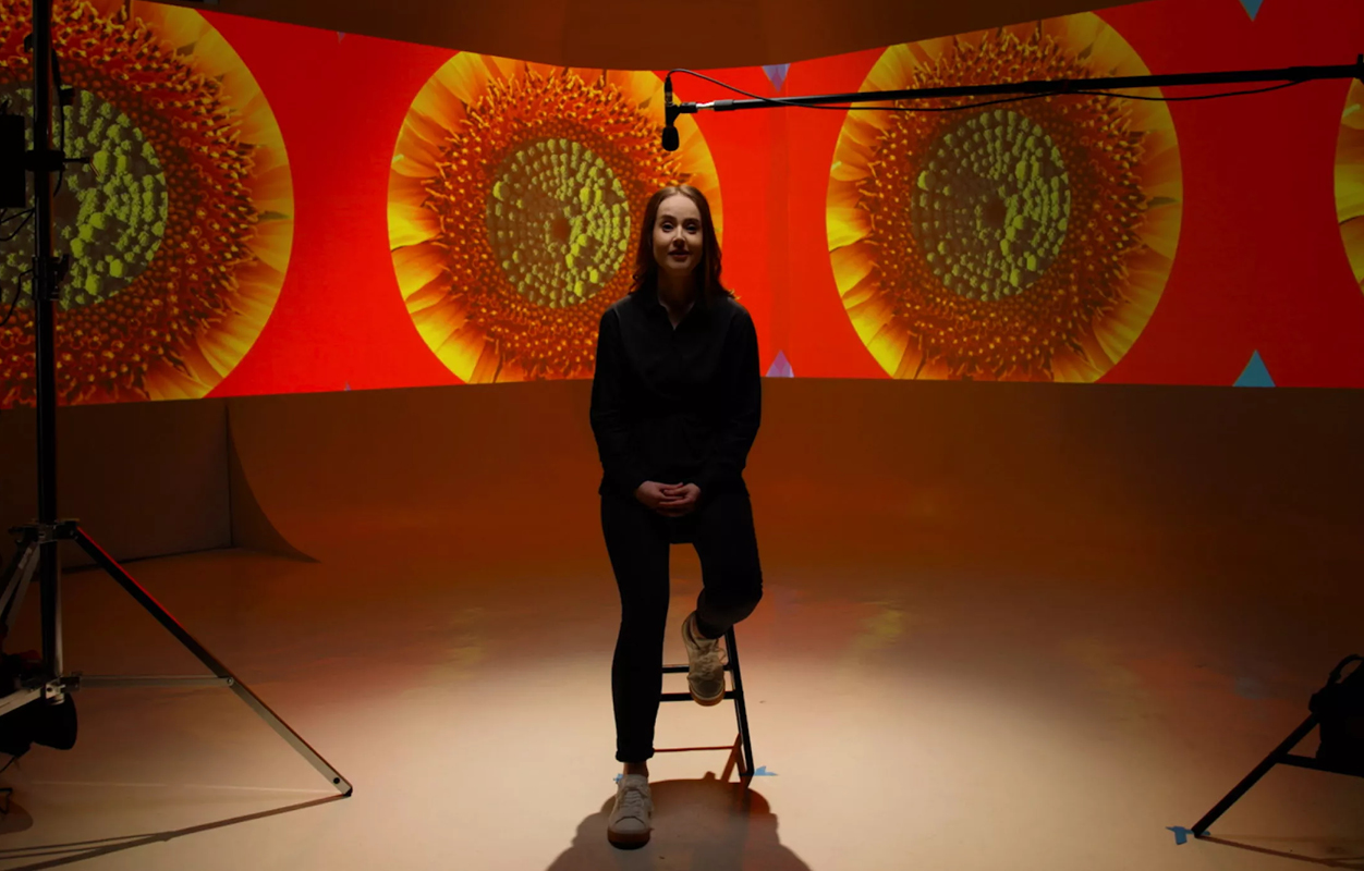 lady sitting in filming studio with projections