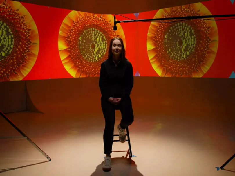 lady sitting in filming studio with projections