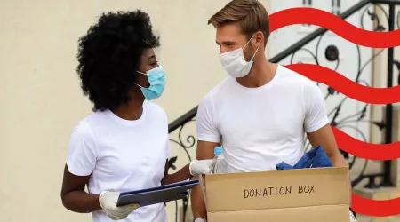 Two people holding a donation box 