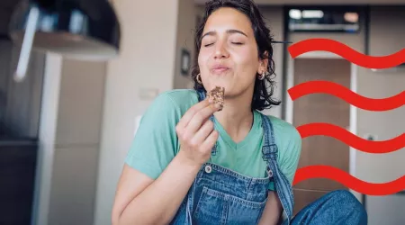 A woman eating cookies in her kitchen