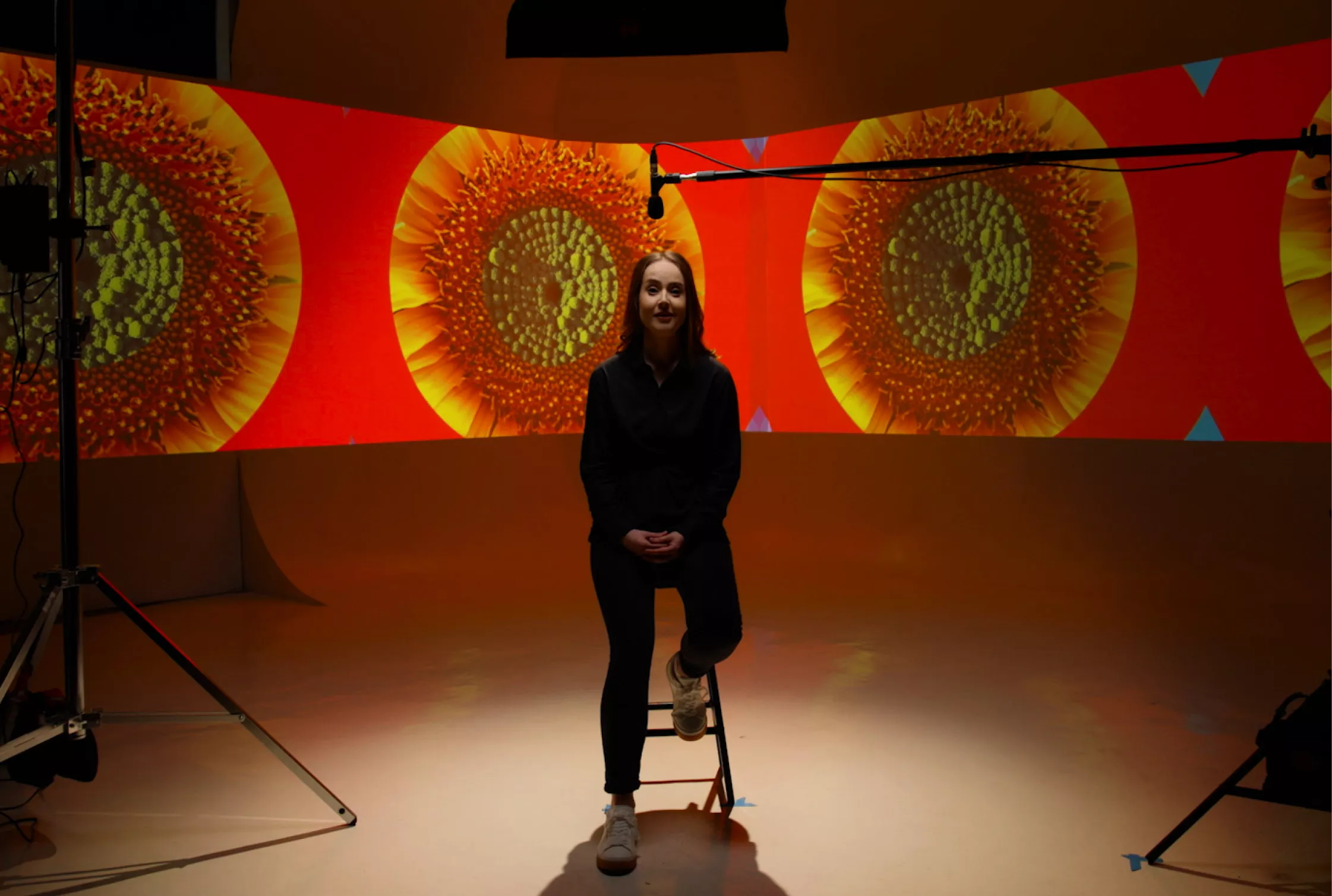 lady sitting in filming studio with projections