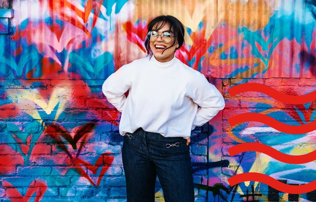  A woman smiling in front of a graffiti wall