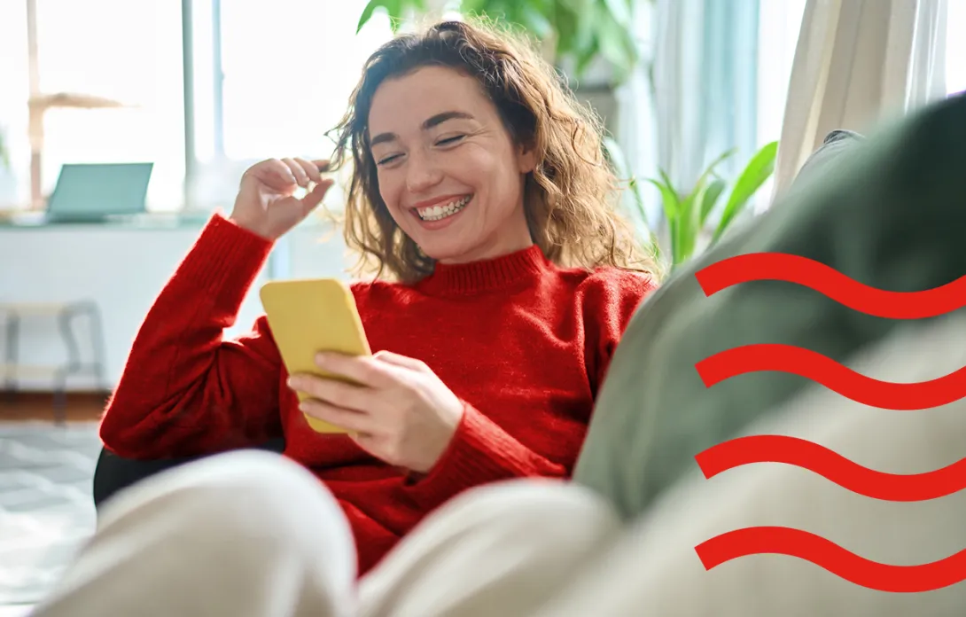 A woman looking at her phone and laughing