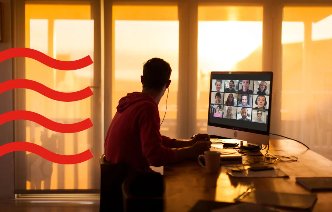 Someone working on their PC while looking out the window at the sunset